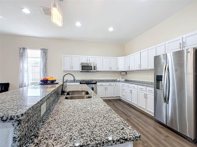 227 Locust Pass Crse, Ocala, FL 34472 - kitchen with stainless steel appliances, a sink, dark wood-style floors, white cabinetry, and stone countertops