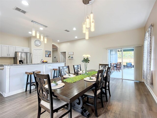 227 Locust Pass Crse, Ocala, FL 34472 - dining room with light wood-style floors, a chandelier, recessed lighting, arched walkways, and baseboards