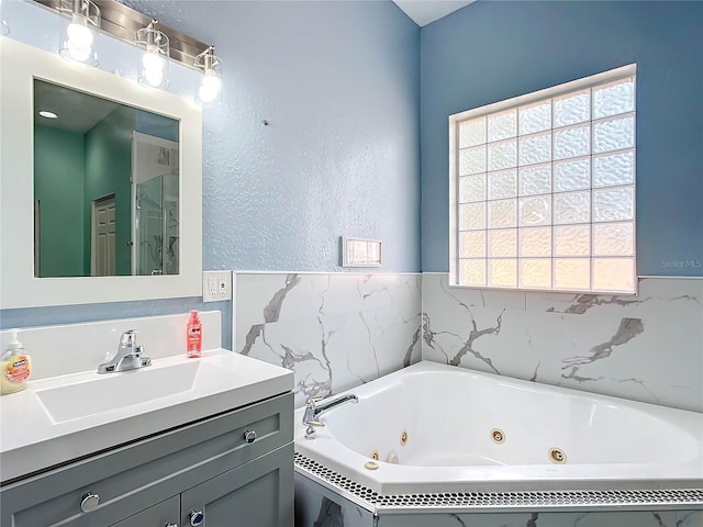 bathroom with a bathtub, a healthy amount of sunlight, and vanity