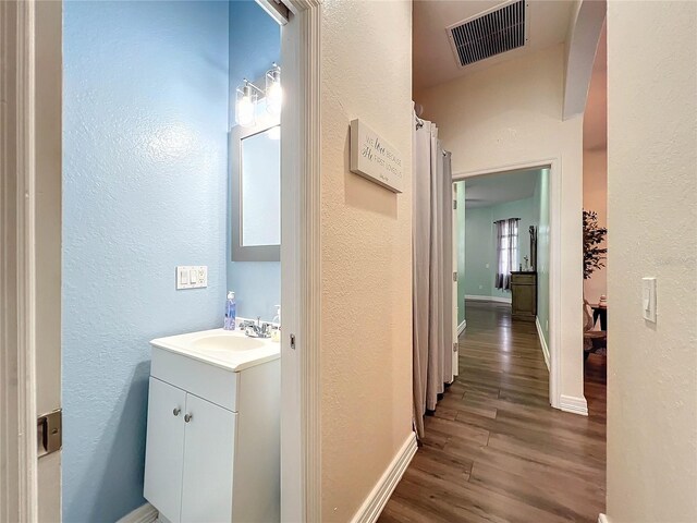 227 Locust Pass Crse, Ocala, FL 34472 - bathroom with a textured wall, wood finished floors, vanity, and baseboards