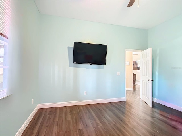 unfurnished bedroom featuring ceiling fan and dark hardwood / wood-style floors