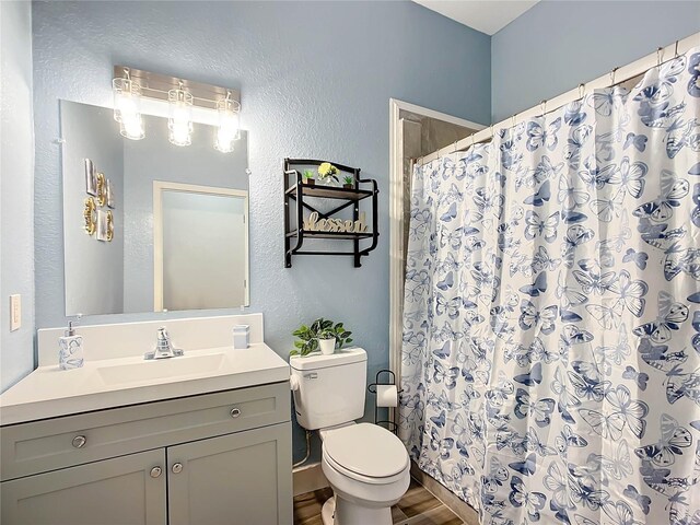 227 Locust Pass Crse, Ocala, FL 34472 - bathroom with a textured wall, toilet, wood finished floors, vanity, and curtained shower