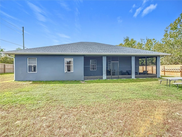 back of house with a sunroom and a lawn