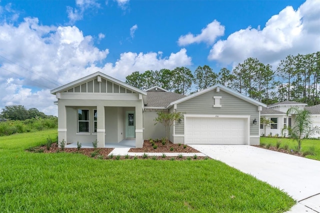 view of front of home with covered porch, a garage, and a front lawn