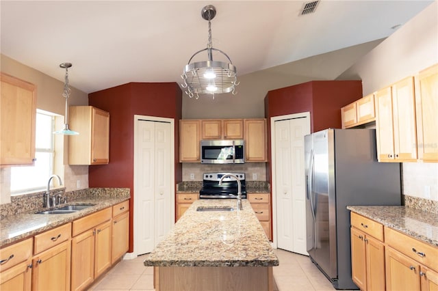 kitchen with light tile patterned flooring, appliances with stainless steel finishes, pendant lighting, sink, and a center island