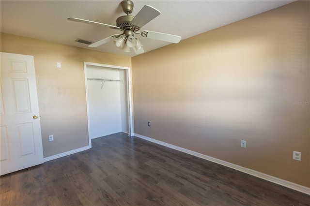 unfurnished bedroom with dark hardwood / wood-style flooring, a closet, and ceiling fan