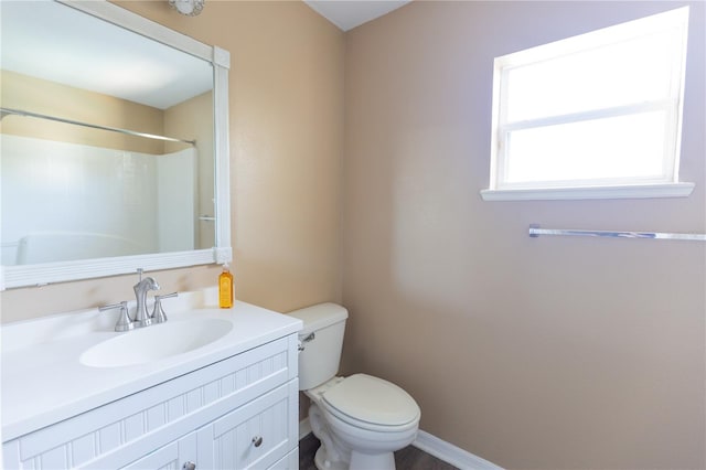 bathroom with vanity, toilet, and a shower