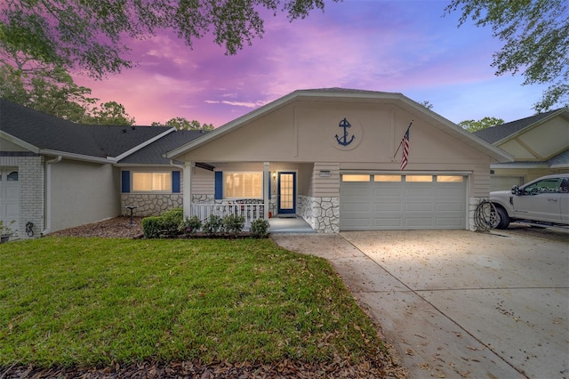 view of front of house featuring a garage, a yard, and covered porch