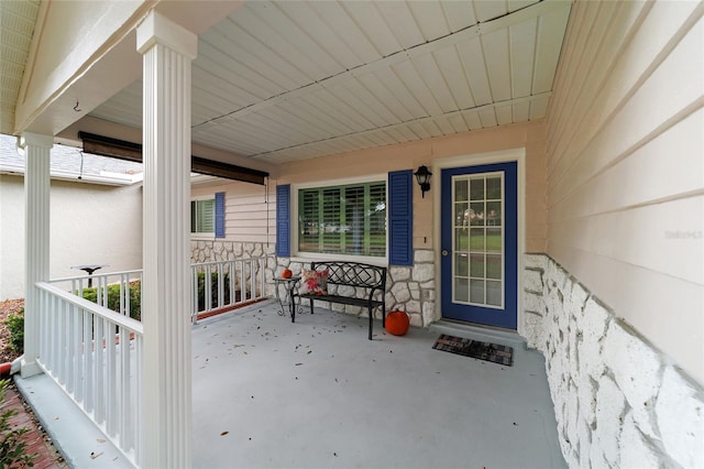 view of exterior entry featuring covered porch