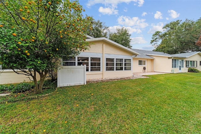 rear view of house with a sunroom and a yard