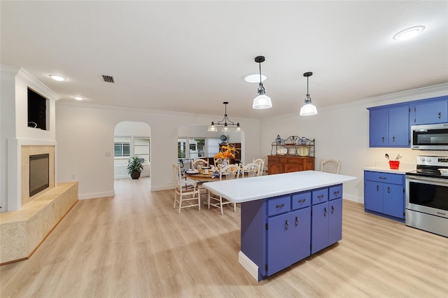 kitchen featuring light hardwood / wood-style floors, a center island, blue cabinets, pendant lighting, and appliances with stainless steel finishes