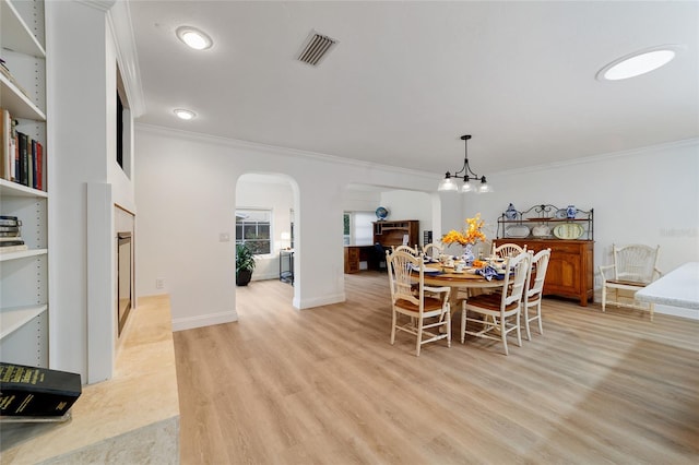 dining area featuring light hardwood / wood-style flooring, a chandelier, and crown molding