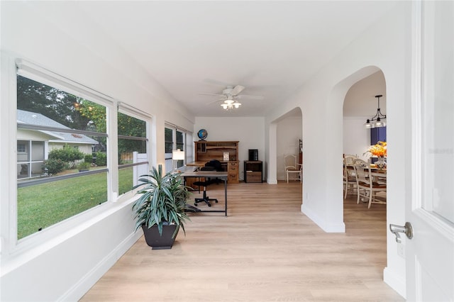 interior space with ceiling fan with notable chandelier