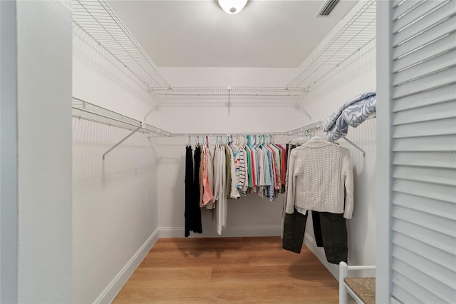 walk in closet with hardwood / wood-style floors