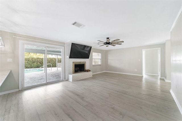 unfurnished living room with hardwood / wood-style floors, ceiling fan, a fireplace, and ornamental molding