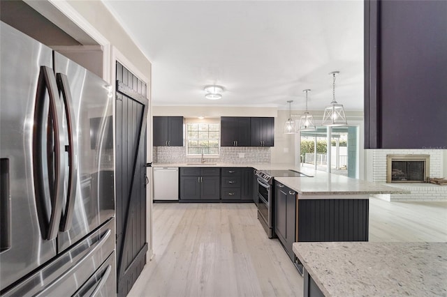 kitchen featuring pendant lighting, stainless steel appliances, light hardwood / wood-style floors, and plenty of natural light