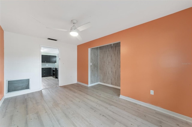 unfurnished living room featuring ceiling fan and light wood-type flooring