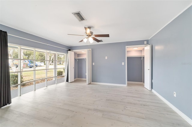 unfurnished room with ceiling fan, light wood-type flooring, and ornamental molding