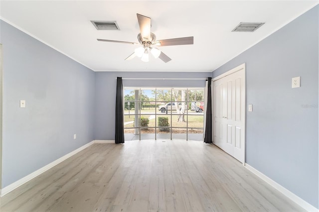 spare room featuring light wood-type flooring, ceiling fan, and crown molding