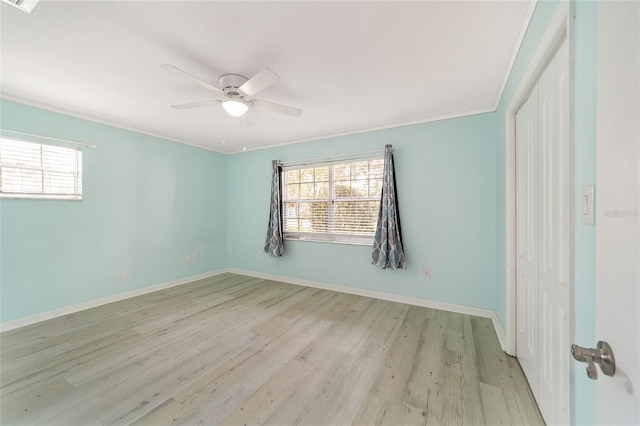 unfurnished room with a wealth of natural light, ceiling fan, crown molding, and light hardwood / wood-style flooring