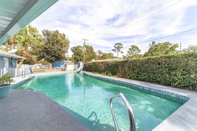 view of pool with a water slide and a patio area