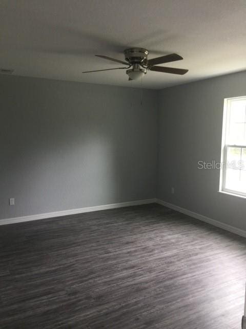 empty room featuring ceiling fan and dark hardwood / wood-style flooring