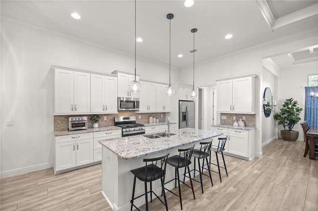 kitchen with pendant lighting, sink, white cabinets, and stainless steel appliances