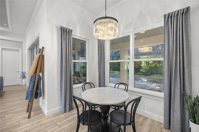 dining room with light hardwood / wood-style flooring, ornamental molding, and a notable chandelier