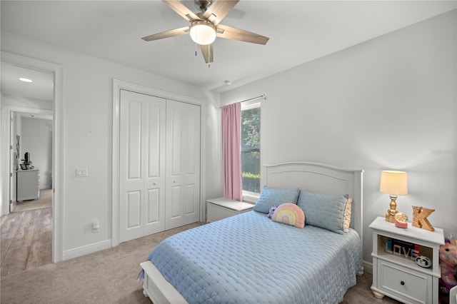 bedroom featuring light carpet, a closet, and ceiling fan