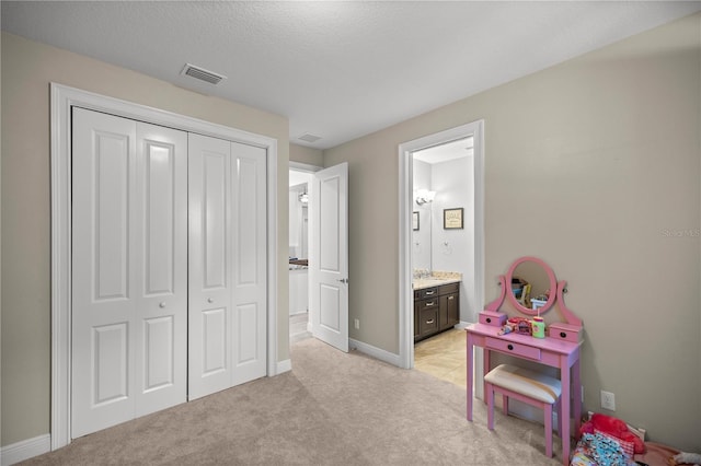 recreation room featuring light carpet and a textured ceiling