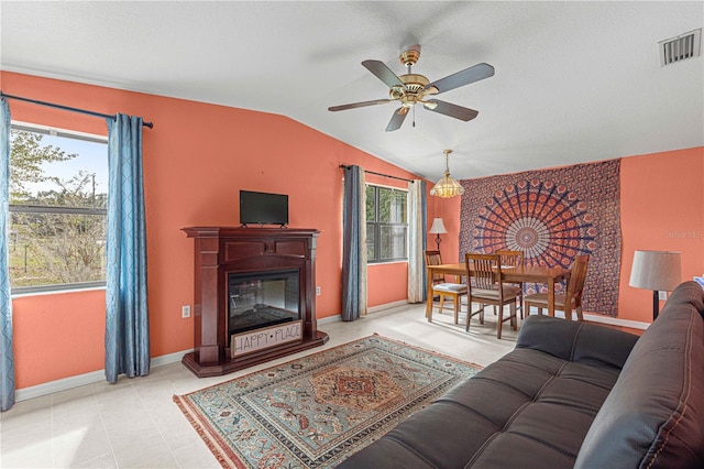 living room featuring a healthy amount of sunlight, ceiling fan, and vaulted ceiling