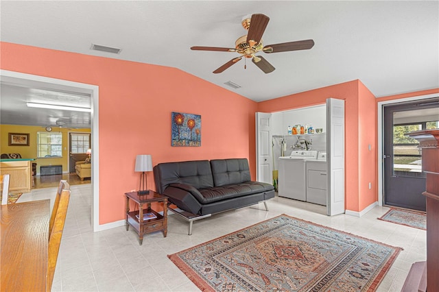 living room with light tile patterned floors, lofted ceiling, washer and dryer, and ceiling fan