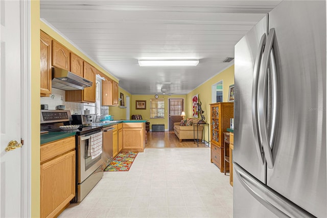 kitchen featuring light hardwood / wood-style floors, ceiling fan, decorative backsplash, and appliances with stainless steel finishes