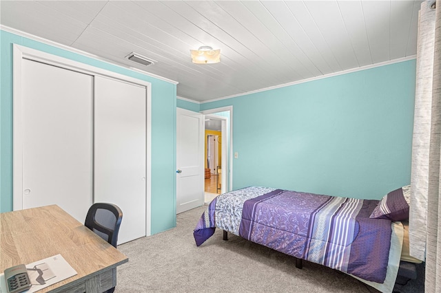 carpeted bedroom featuring a closet and crown molding