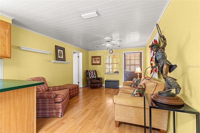 living room featuring ornamental molding, light hardwood / wood-style flooring, and ceiling fan