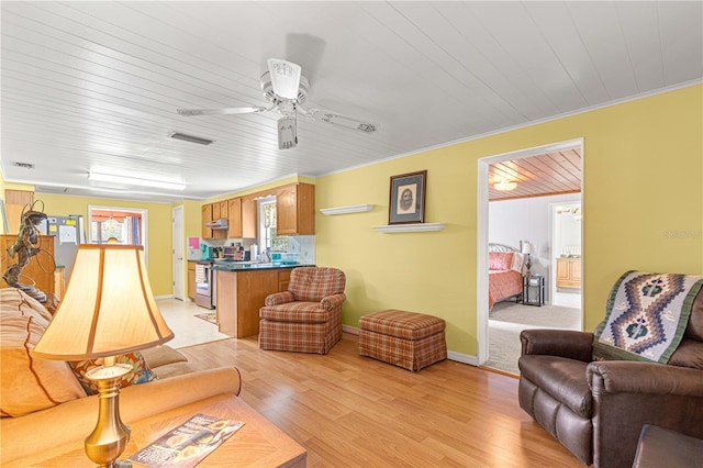 living room featuring ceiling fan, light wood-type flooring, and ornamental molding