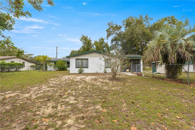 back of property featuring a sunroom and a yard