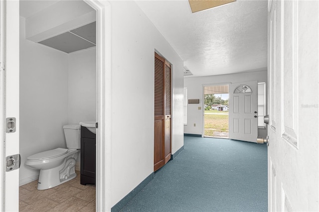 carpeted entryway with a textured ceiling