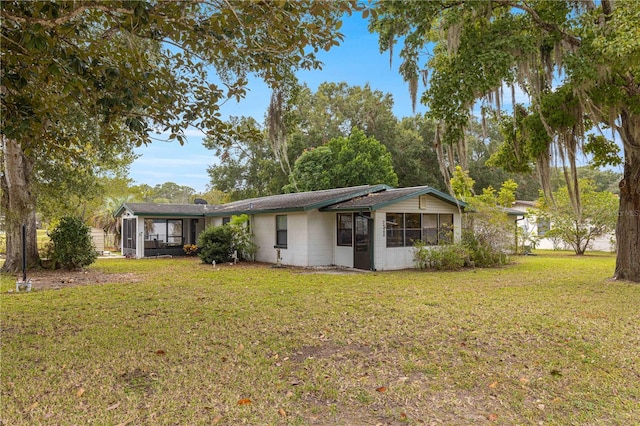 back of property featuring a lawn and a sunroom