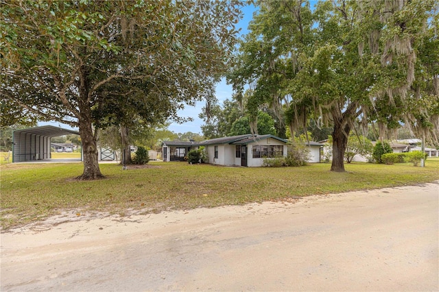 view of front of property featuring a front lawn and a carport