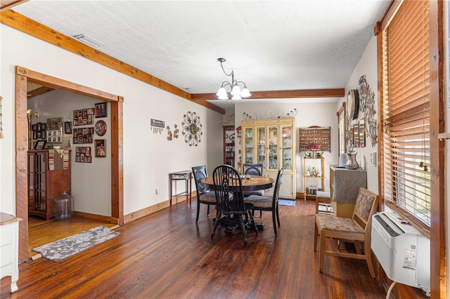 dining room featuring dark hardwood / wood-style flooring, an inviting chandelier, and a textured ceiling