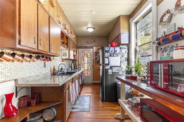 kitchen featuring black fridge, sink, tasteful backsplash, wood ceiling, and light wood-type flooring