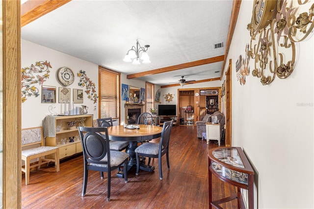 dining room with a textured ceiling, ceiling fan with notable chandelier, beamed ceiling, and dark hardwood / wood-style floors