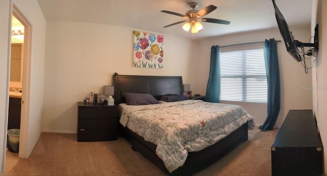 bedroom with carpet floors, ceiling fan, and connected bathroom