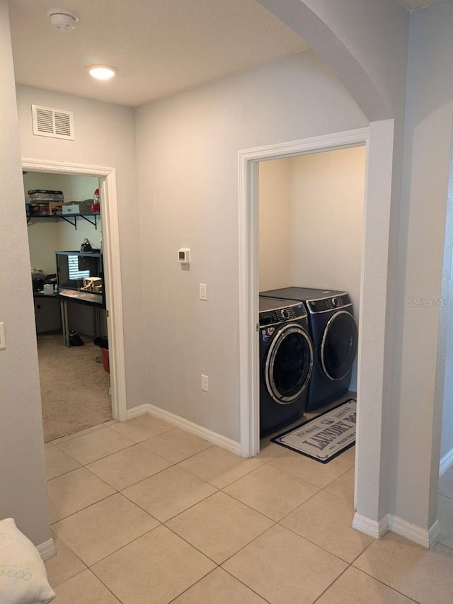 laundry room featuring washer and dryer and light tile patterned floors