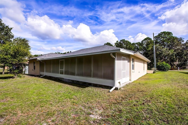 view of side of home featuring a sunroom and a lawn