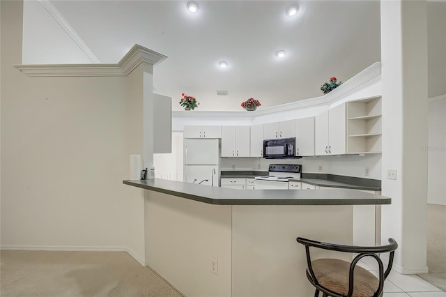 kitchen with kitchen peninsula, light carpet, a kitchen breakfast bar, white cabinetry, and white appliances