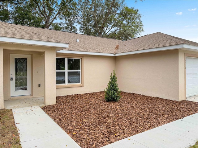 view of exterior entry with a garage