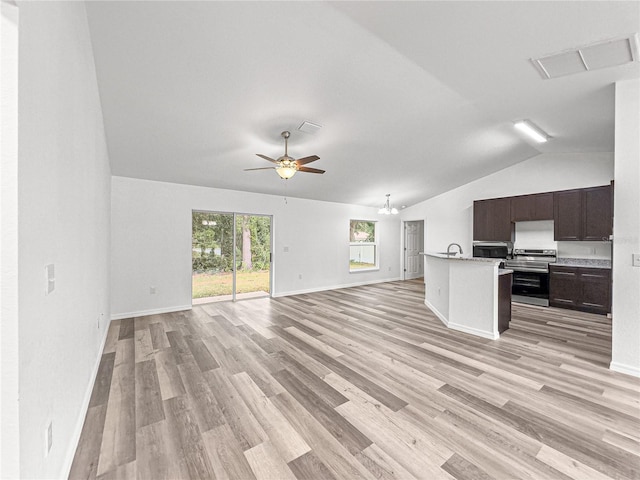 unfurnished living room with ceiling fan with notable chandelier, light hardwood / wood-style flooring, lofted ceiling, and sink