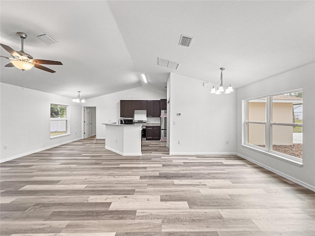 unfurnished living room featuring ceiling fan with notable chandelier, light hardwood / wood-style flooring, and lofted ceiling